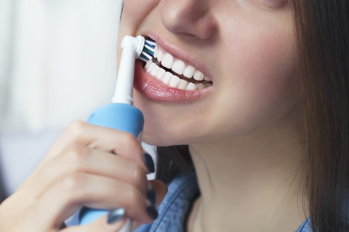 close up of girl brushing her teeth