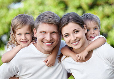 Family of Four Smiling Outside